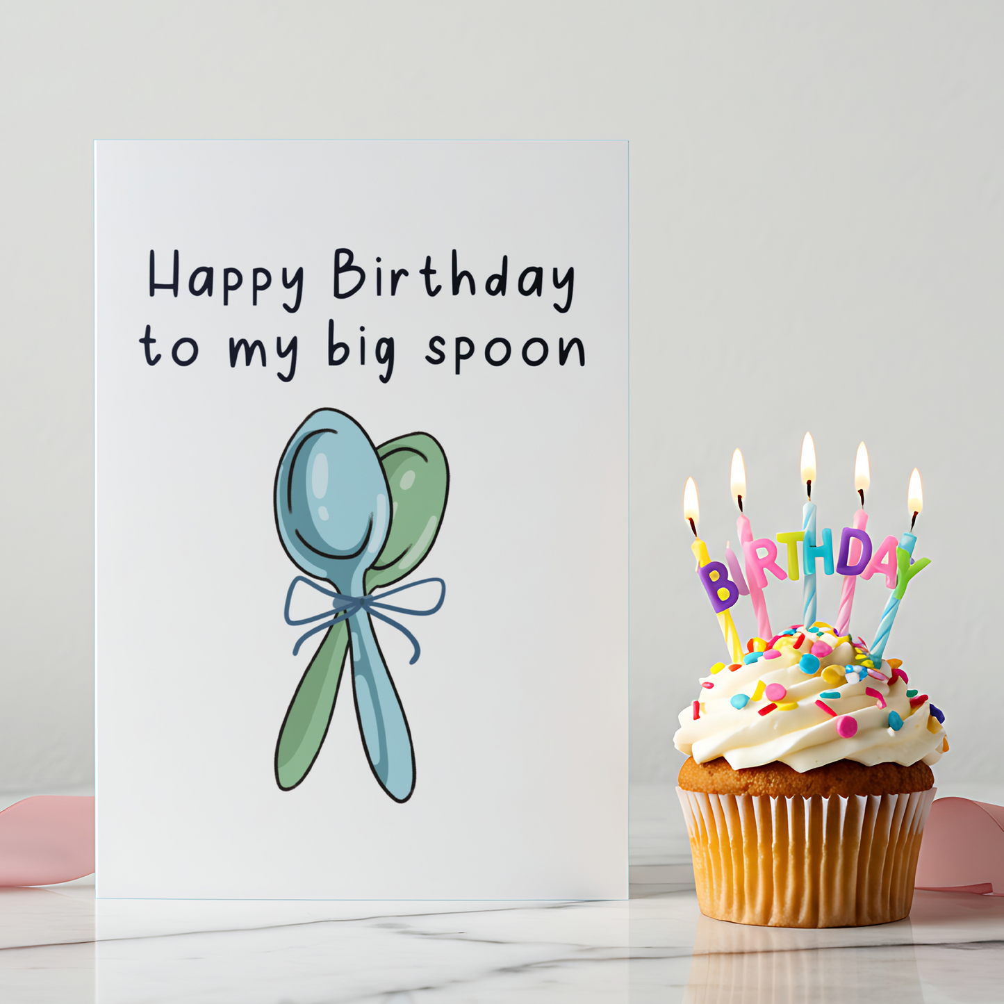 Cute birthday card featuring two spoons tied together with a ribbon, symbolizing a big spoon and little spoon relationship. The clean white background and soft colors create a warm and cozy birthday vibe.