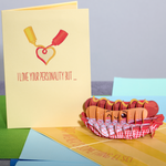 A pop-up card showcasing a hot dog in a basket, a funny Valentine's Day card exclaiming 'That weiner is something else!