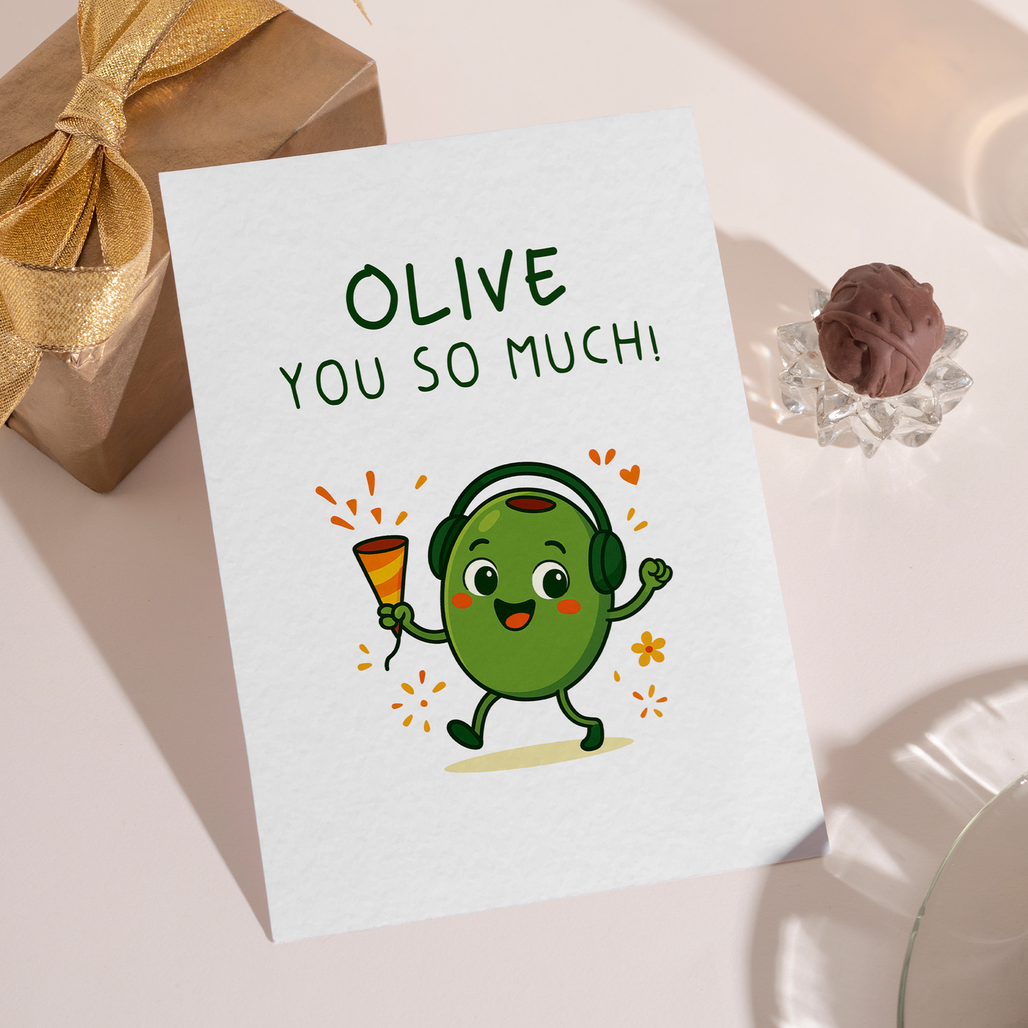 Adorable cartoon olive enjoying a happy moment with festive elements around it. The simple composition and friendly design make the card feel warm and upbeat.