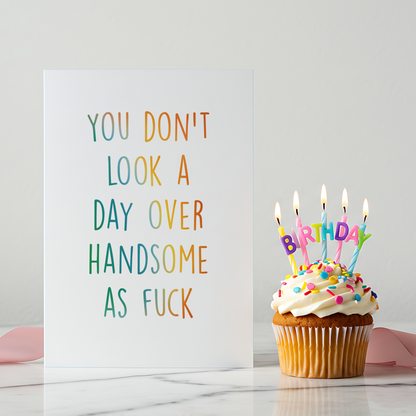 Stylish funny birthday card photographed on a light wooden surface with soft decorative elements. Designed for bold celebrations and confident personalities.