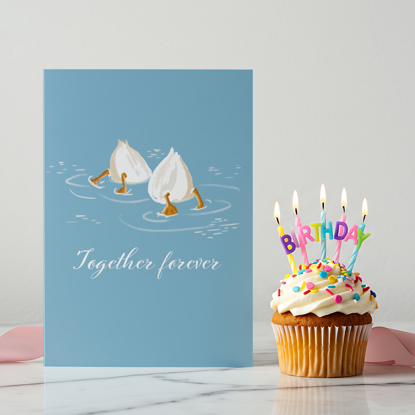 Cute love greeting card featuring two illustrated garlic cloves swimming together on a soft blue background. The phrase “Together forever” adds a romantic and playful touch ideal for couples.