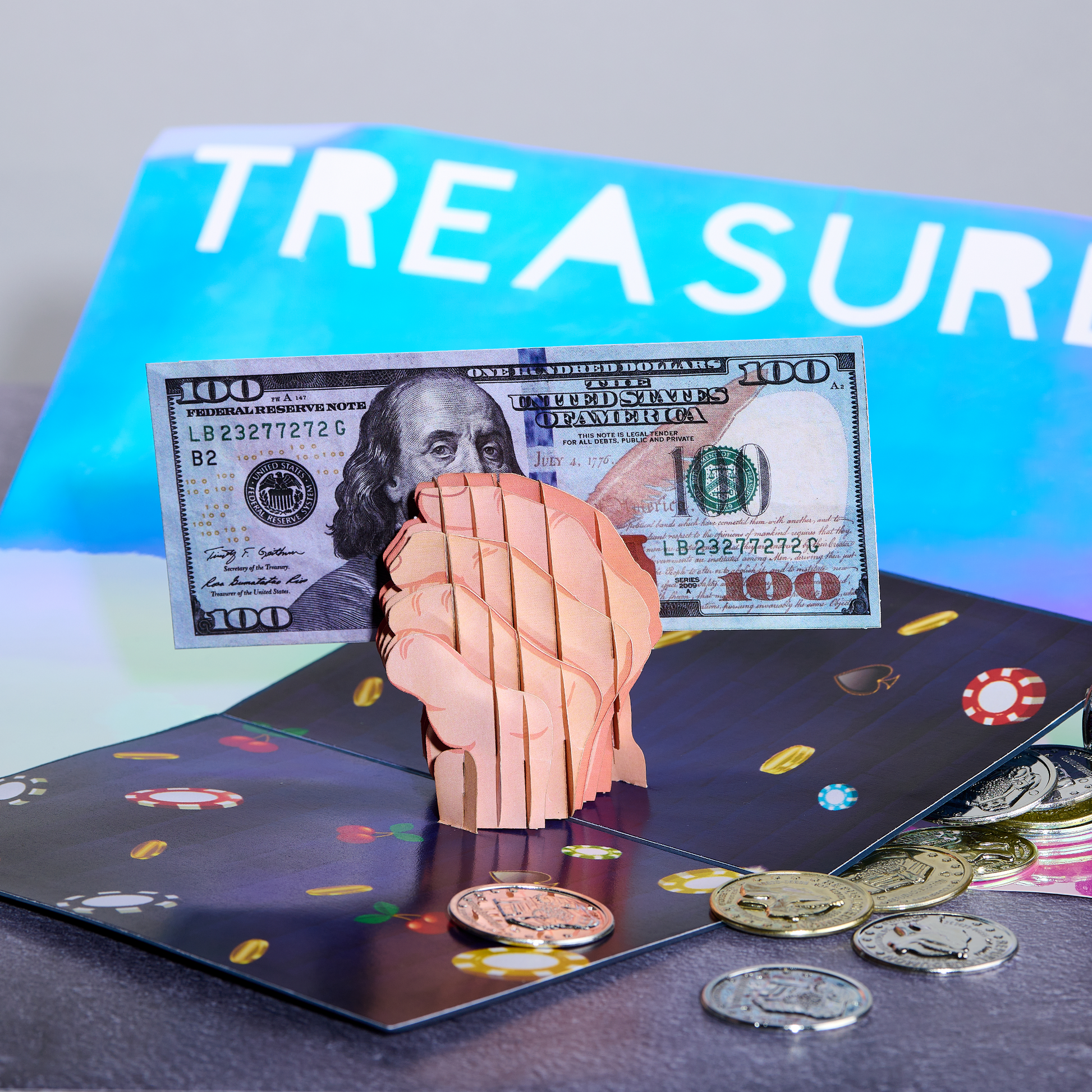 A 3D pop-up card with a clenched fist holding a $100 bill, surrounded by poker chips and coins on a casino-themed background. The word TREASURE is partially visible in the background.