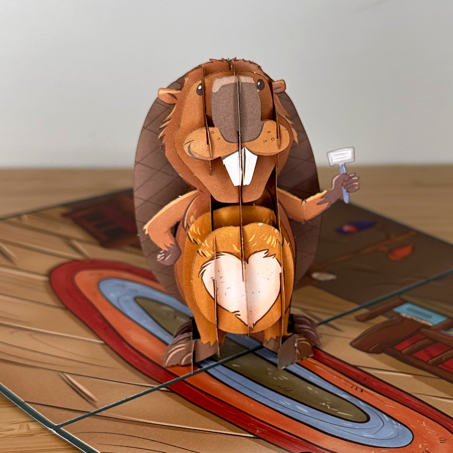 Whimsical beaver paper cutout with a shaver, showcasing a shaved heart on its belly.