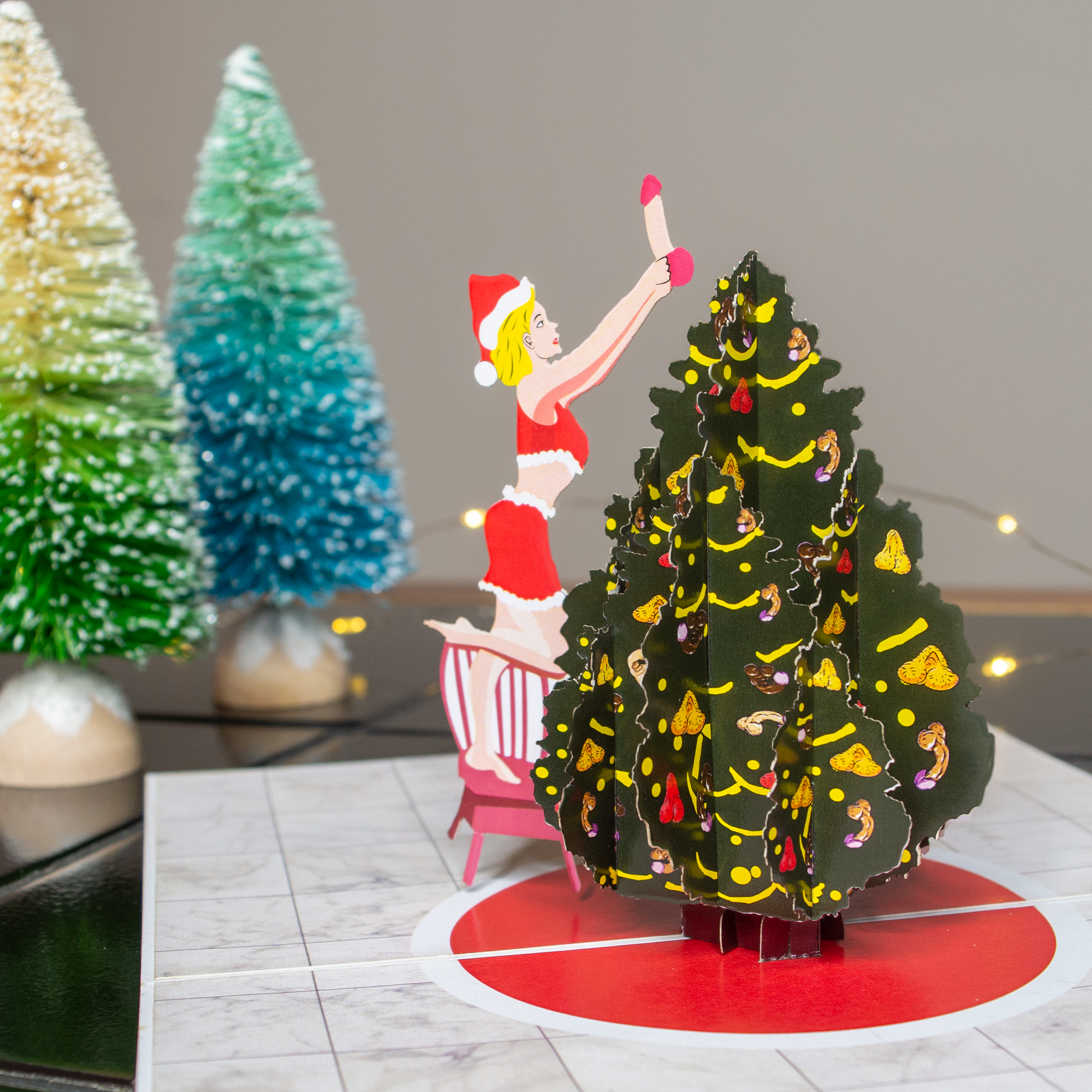 Spread holiday joy with a inappropriate pop-up card showing a woman in a Santa hat and a Christmas tree. Perfect for celebrating the season!