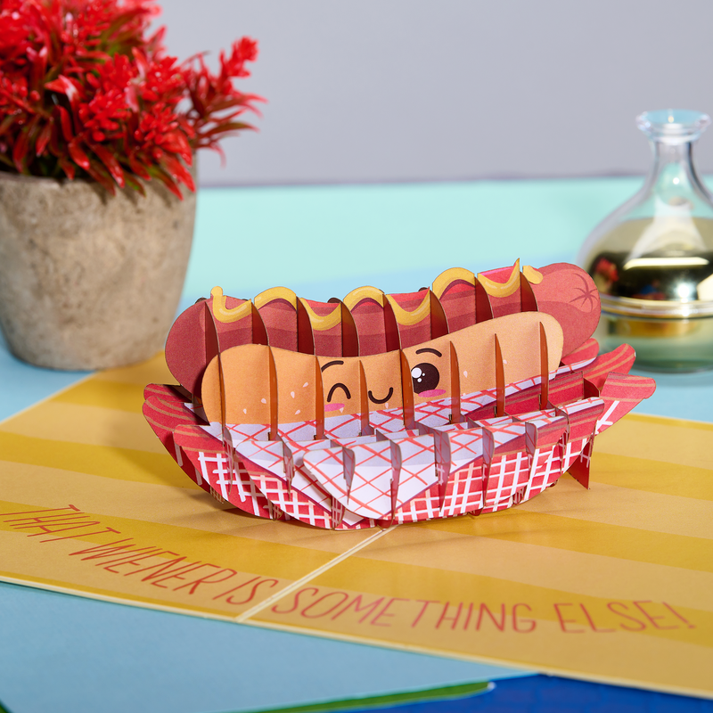 A pop-up card with a hot dog in a basket, a funny Valentine's Day card that says 'That weiner is something else!
