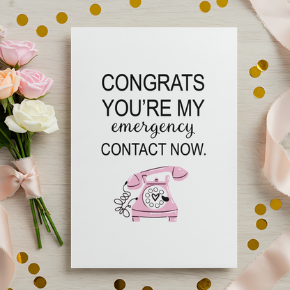 Modern funny greeting card showing a pink vintage telephone under a playful message about becoming an emergency contact. The clean aesthetic and witty tone appeal to women shopping for unique relationship, anniversary, or Valentine’s Day cards.