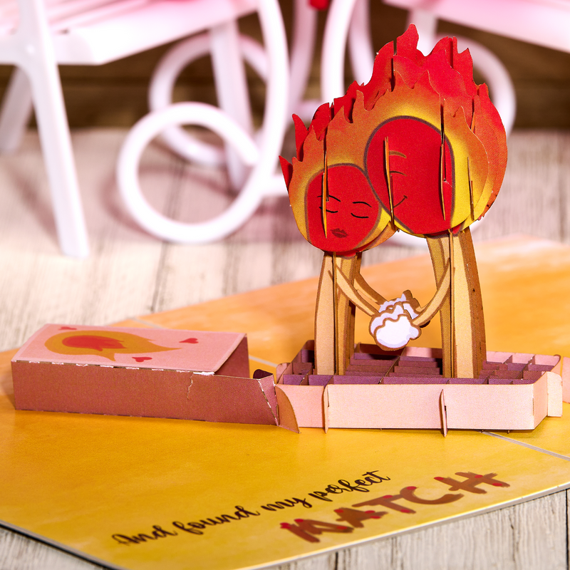 A pop-up card with a fiery background and a couple kissing. It represents finding the perfect match in online dating.