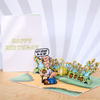 Funny birthday pop-up card with a cartoon of a man in a field, releasing gas amidst sad sunflowers