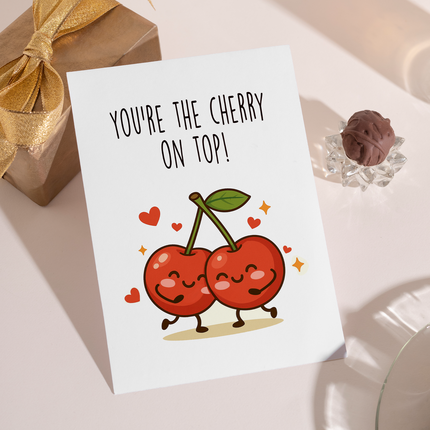 Whimsical greeting card featuring two cute cherries smiling and holding hands beneath the text “You’re the cherry on top.” The friendly illustration and sweet wording make it ideal for birthdays, love notes, or everyday appreciation.