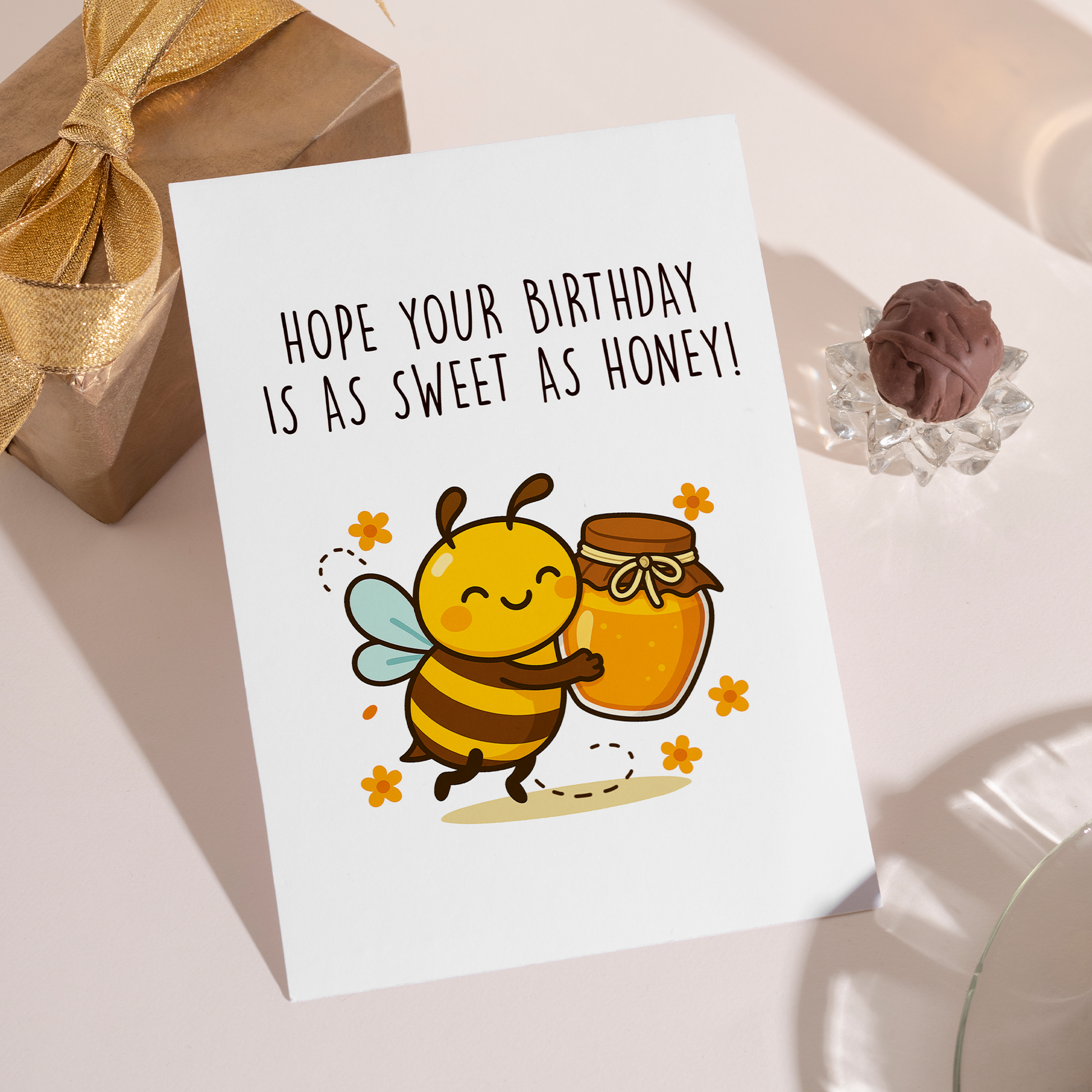 Charming birthday greeting card featuring a cute bee hugging honey while surrounded by small flowers. The design pairs gentle humor with a sweet sentiment that feels warm and uplifting.