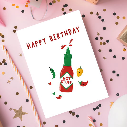 A playful birthday card featuring a red hot sauce bottle labeled hot stuff with cute smiling chili peppers. The bright colors and clean white background create a fun and cheerful birthday design.