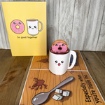  A cup with a donut inside, a spoon on a table. A humorous anniversary pop-up greeting card of a donut being dipped in coffee.