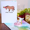 Colorful pop up card featuring a unicorn dancing on a pole, set against a rainbow background with fluffy clouds.