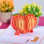 Playful anniversary card: an apple-shaped peach pops up, adding a touch of humor to your celebration!