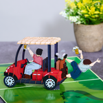 Two men joyfully drive a golf cart, laughing and celebrating in a funny pop-up card.