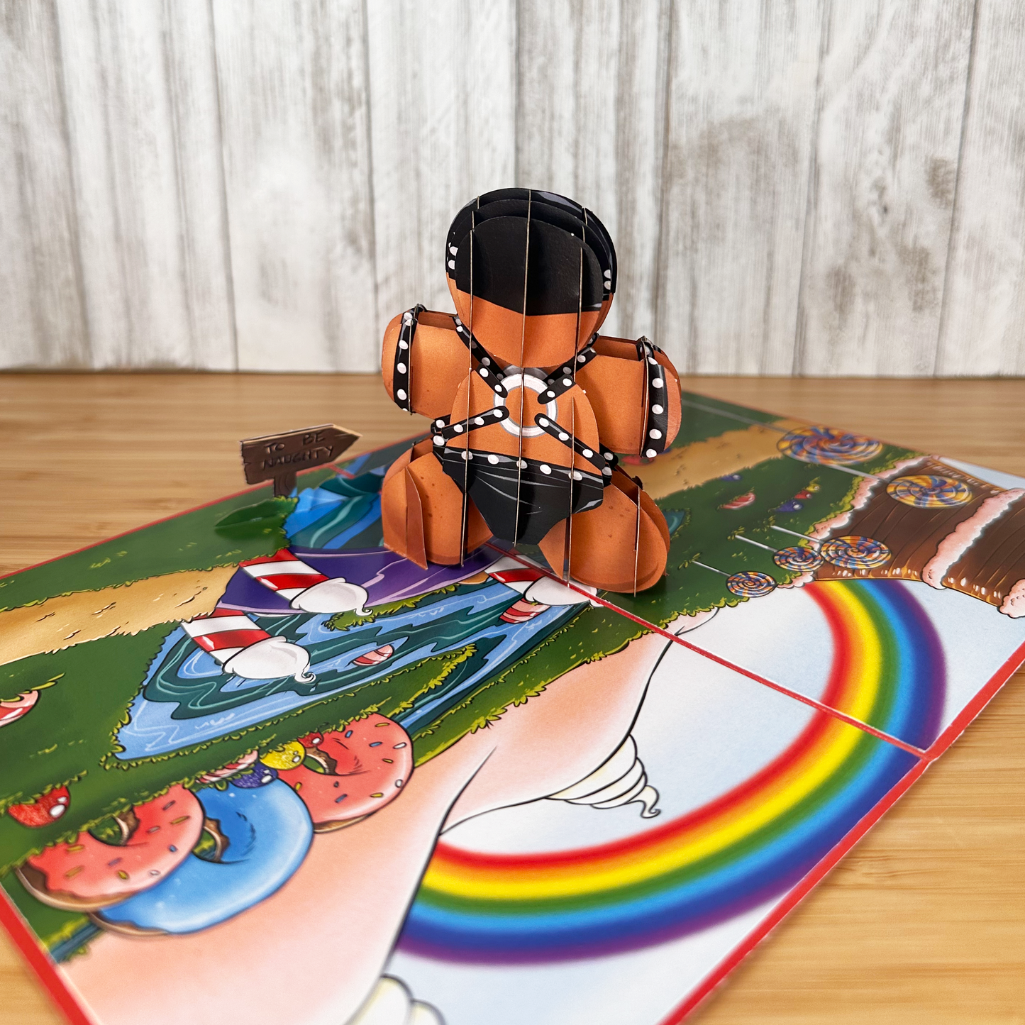 backside of  funny christmas card of a pop up gingerbread man wearing latex for the holidays