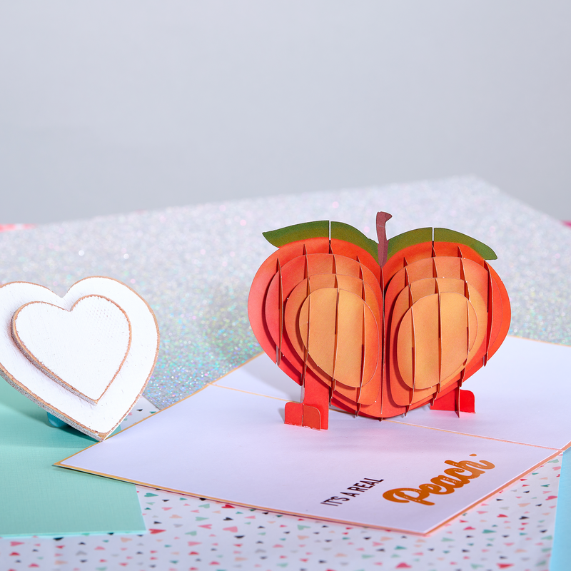 Funny anniversary pop-up card with an apple-shaped peach. Perfect for a playful celebration!