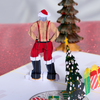 A jolly Santa in a red suit stands by a Christmas tree, holding two big ornaments. Get ready for some festive fun!