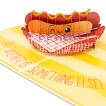 A humorous pop-up Valentine's Day card featuring a hot dog in a basket, with the text 'That weiner is something else!