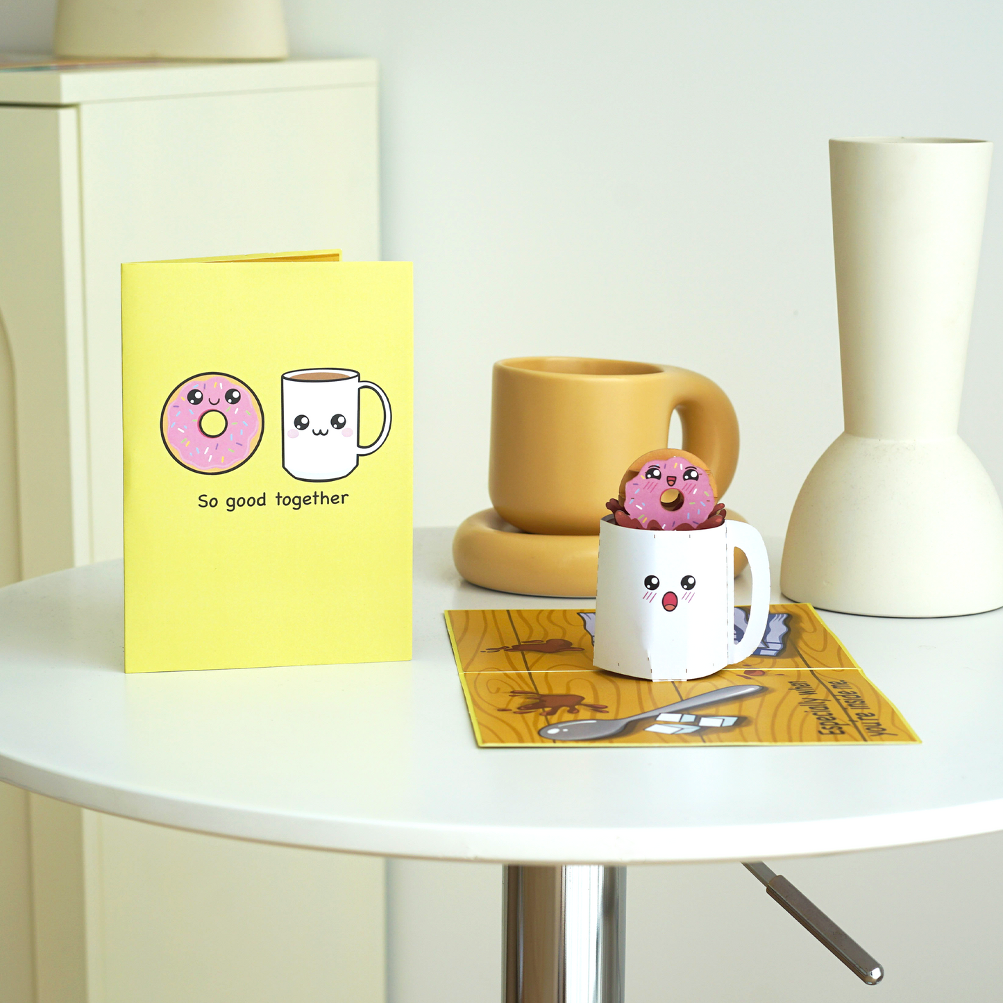 A cute pop-up card with a doughnut and coffee mug illustration on the cover, reading So good together. Inside, a 3D doughnut sits inside a smiling coffee mug, highlighting the fun and charming theme of the card.