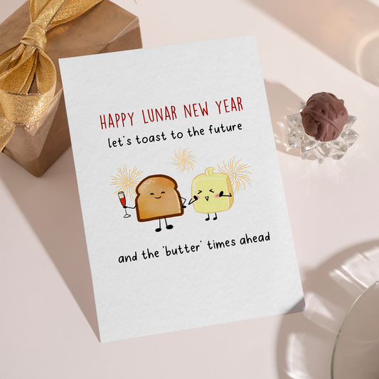 Cute illustrated toast and butter characters celebrating the Lunar New Year with drinks and fireworks. The design uses warm colors and humor to suggest better times ahead.
