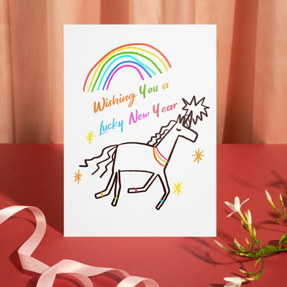 Adorable illustrated card with a unicorn, rainbow, and star accents celebrating a lucky new year. The design feels cheerful, uplifting, and perfect for new beginnings.