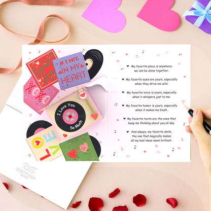 An open 3D pop-up greeting card with a vintage vinyl record theme, featuring illustrated records, romantic messages, and musical notes. A hand writes inside the card, surrounded by heart decorations, ribbon, and rose petals, creating a heartfelt and nostalgic love letter aesthetic.