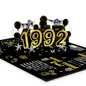 A 3D pop-up card featuring the year '1992' in glittery gold numbers, surrounded by balloons, stars, and retro-themed illustrations on a black background with facts and graphics from 1992