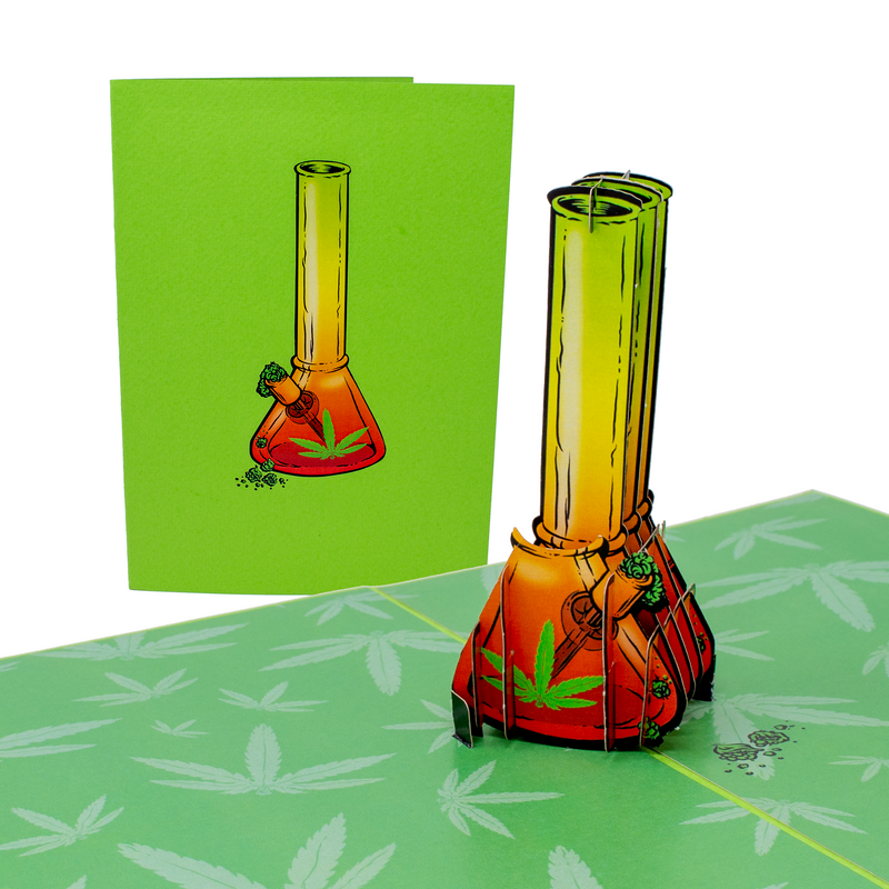 A pop-up card with a 3D bong design stands open, displaying a colorful bong illustration on a green background with cannabis leaves. Next to it is the closed card, featuring the same bong illustration, emphasizing a fun and vibrant theme.