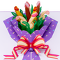 A colorful pop-up card featuring a bouquet with playful, abstract shapes resembling phallic symbols in various skin tones, surrounded by green leaves and wrapped in a purple paper with a pink and yellow striped bow.