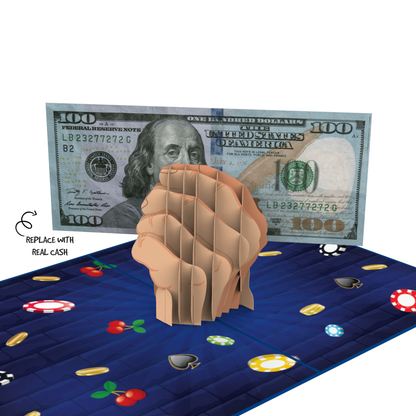 A 3D pop-up card featuring a clenched fist holding a simulated $100 bill, with poker chips and playing cards on a blue background. Text reads 'Replace with real cash' next to the bill.