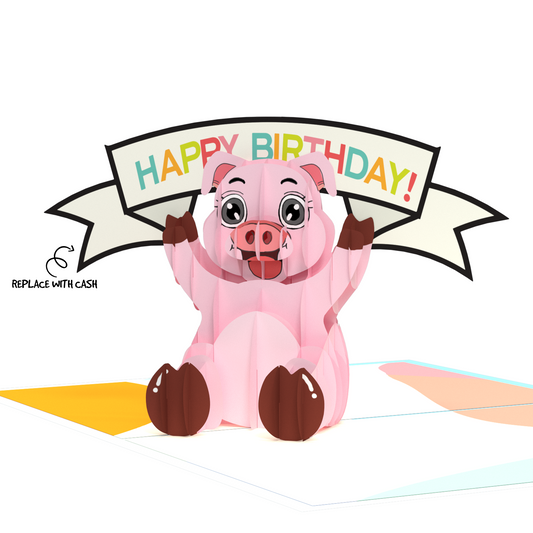 A pop-up card featuring a cute, pink piggy bank with raised arms holding a banner that says HAPPY BIRTHDAY! A small arrow on the left points to the piggy, with the text REPLACE WITH CASH.
