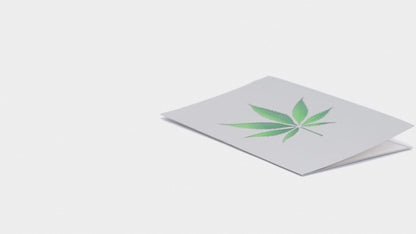 A video shows a pop-up card opening to reveal a 3D cannabis plant, with detailed green leaves unfolding. The camera pans around the card, capturing its intricate design and realistic texture.