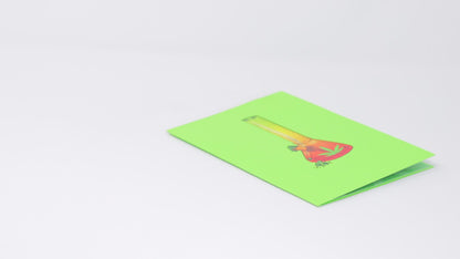 A video shows a pop-up card with a 3D bong design being opened and displayed. The camera pans around to capture the colorful details of the bong illustration, while a real bong and lighter are placed nearby, enhancing the playful theme.